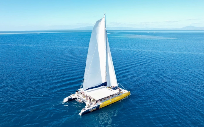 Catamaran sailing on clear blue ocean during Sabre Sunset Cruise with BBQ Dinner & Drinks.