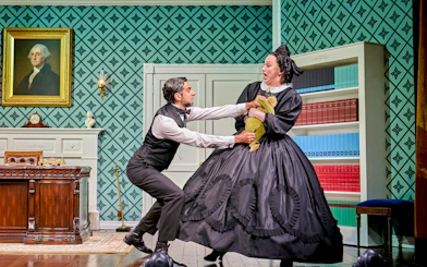 Man and woman in period costumes in a dramatic scene from "Oh Mary!" play.