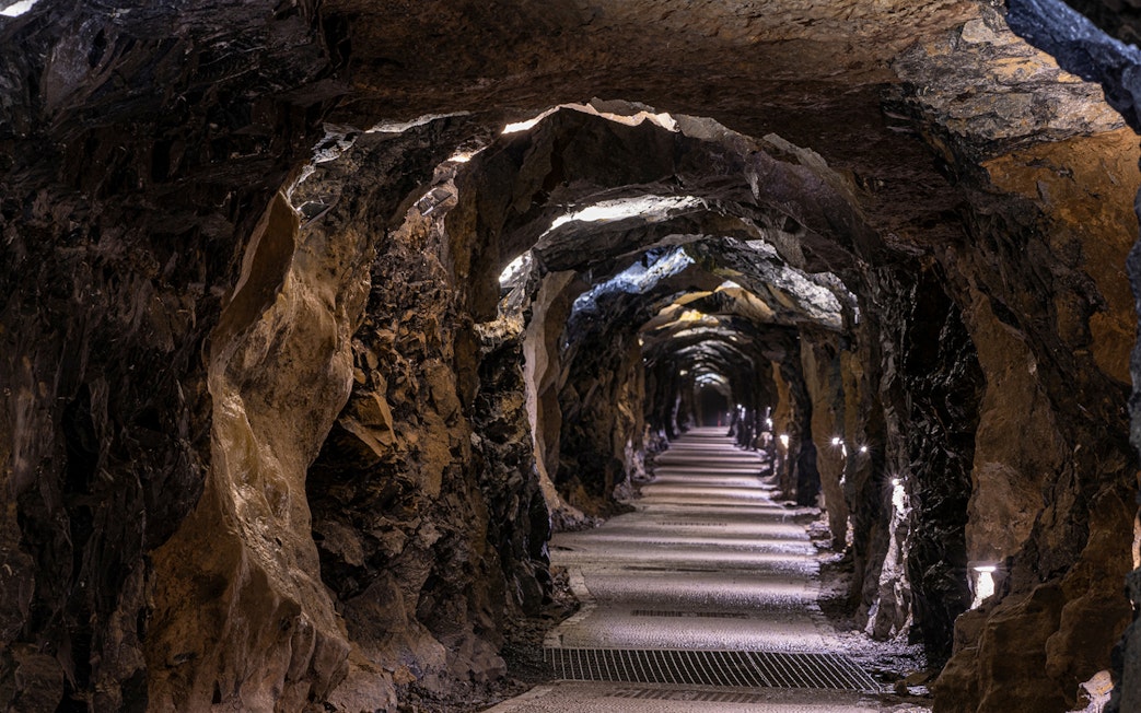 Aillwee Caves tunnel with illuminated rocky walls and pathway.
