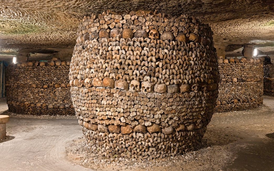 Barrel-shaped structure of bones and skulls in the Catacombs’ Ossuary, Paris.