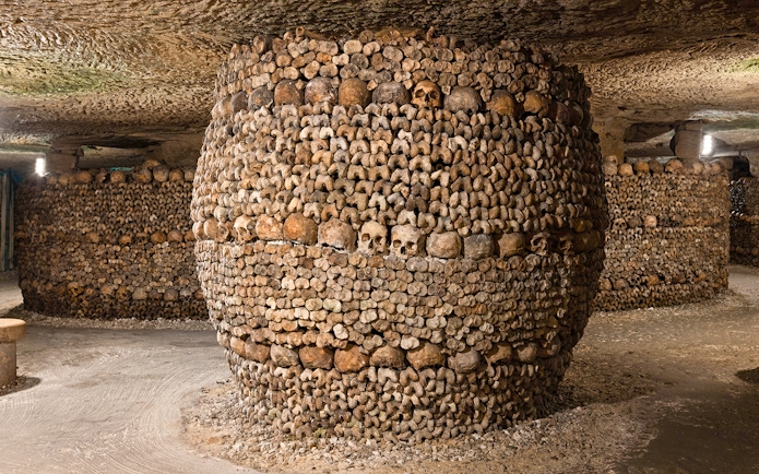Barrel-shaped structure of bones and skulls in the Catacombs’ Ossuary, Paris.