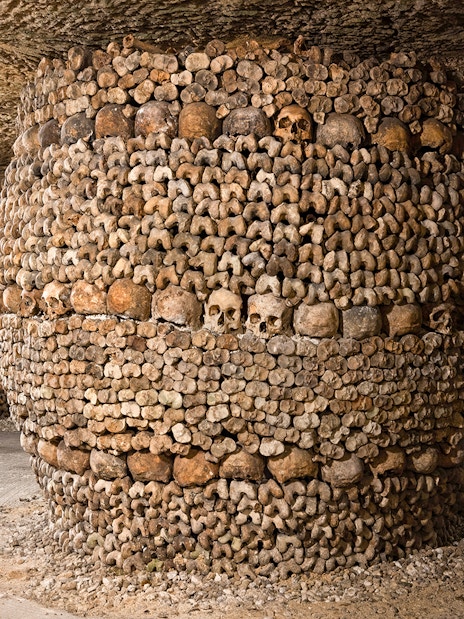 Barrel-shaped structure of bones and skulls in the Catacombs’ Ossuary, Paris.