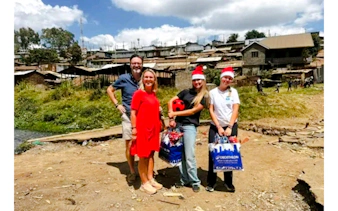 Group visiting Kibera Slum in Nairobi with gifts, part of guided walking tour and children's home visit.