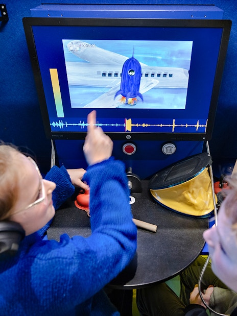 Kids interacting with a science experiment display at the museum.