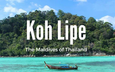 Ferry near lush island of Koh Lipe, Thailand, with turquoise waters.