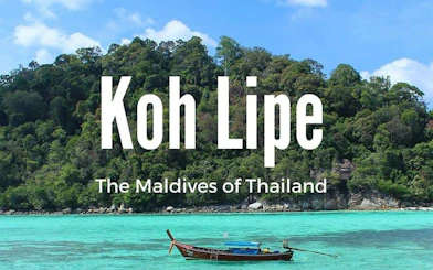 Ferry near lush island of Koh Lipe, Thailand, with turquoise waters.