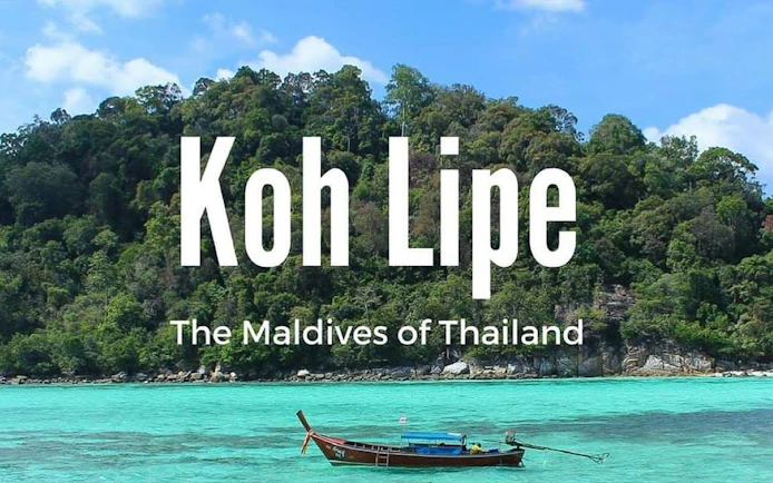 Ferry near lush island of Koh Lipe, Thailand, with turquoise waters.