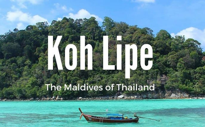 Ferry near lush island of Koh Lipe, Thailand, with turquoise waters.