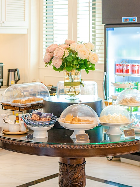 Buffet spread at The Coral Executive Lounge, Bangkok Airport, featuring pastries and beverages.