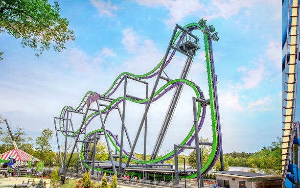Roller coaster at Six Flags Great Adventure with green and purple tracks.
