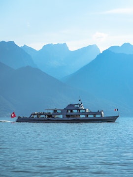 Cruise boat on Lake Geneva with mountains in the background.