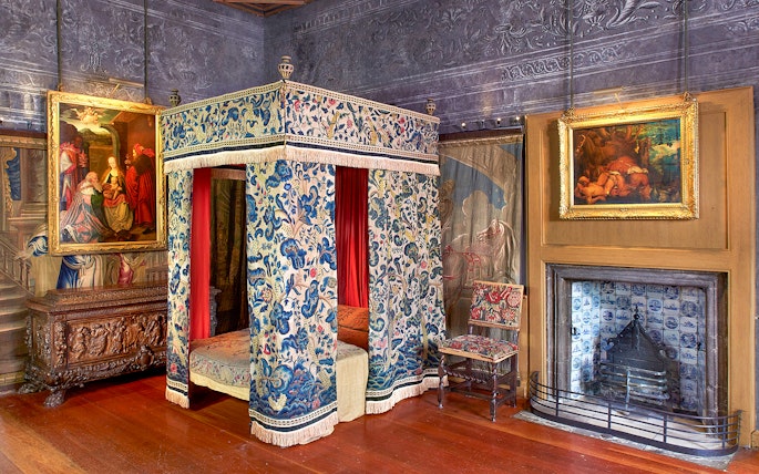 Ornate room with a canopy bed and paintings at Palace of Holyroodhouse, Edinburgh.