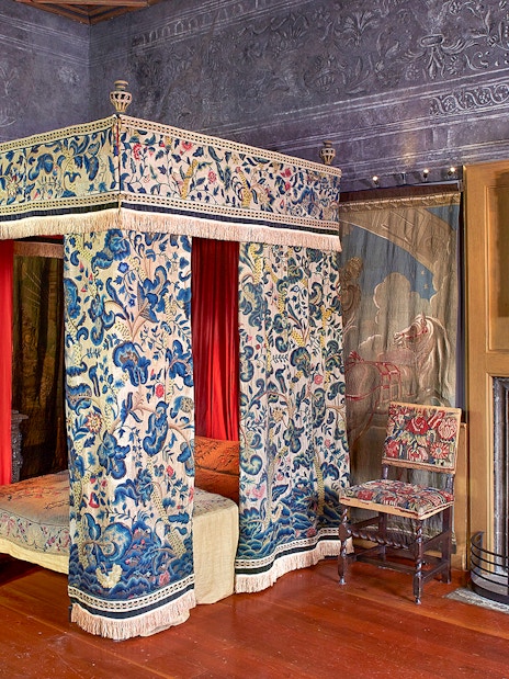 Ornate room with a canopy bed and paintings at Palace of Holyroodhouse, Edinburgh.