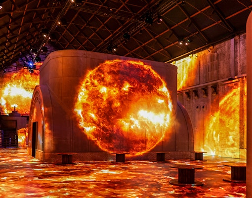 Fabrique des Lumières exhibit with cosmic projections on walls and floor.