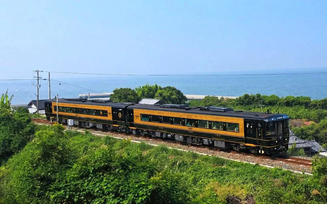 Kyushu scenic train traveling along the coastline with ocean view.