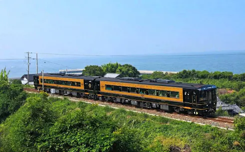 Kyushu scenic train traveling along the coastline with ocean view.