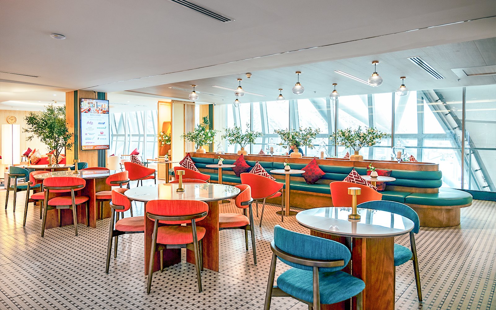 Coral Airport Lounge seating area at Suvarnabhumi Airport with tables and chairs.