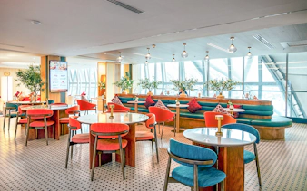 Coral Airport Lounge seating area at Suvarnabhumi Airport with tables and chairs.