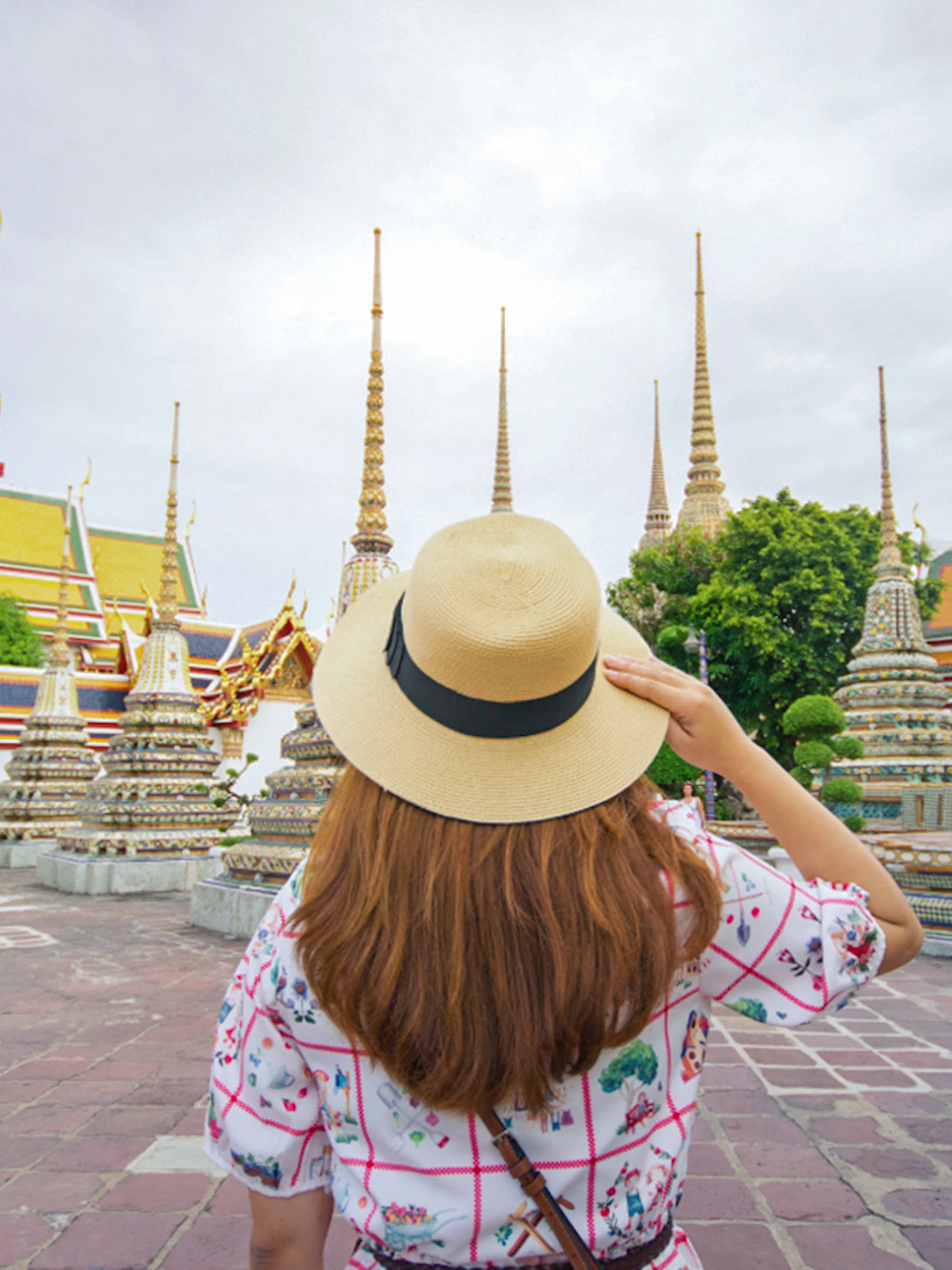 Visitor exploring Wat Pho temple complex in Bangkok, Thailand.