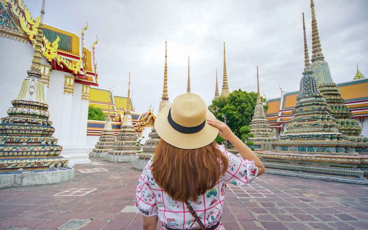 Visitor exploring Wat Pho temple complex in Bangkok, Thailand.