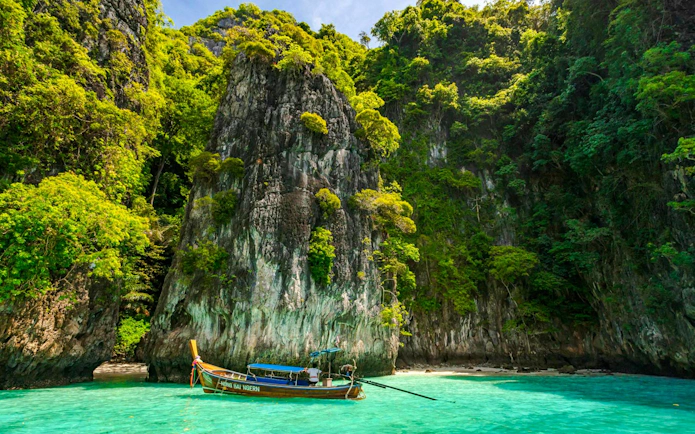 Catamaran near limestone cliffs and turquoise water, Phi Phi Islands, Phuket tour.