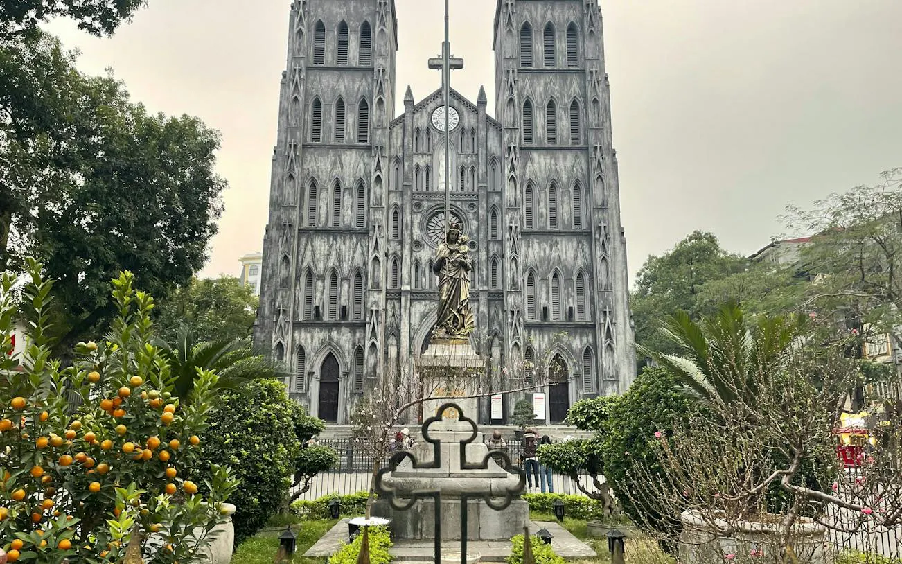 St. Joseph's Cathedral facade with garden, Hanoi Old Quarter exploration game.