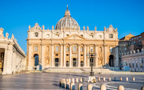 St. Peter's Basilica facade in Vatican City with clear blue sky.