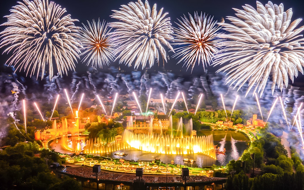 Fireworks display over Puy du Fou theme park in France during a night light show.
