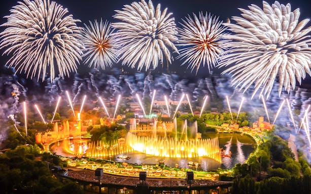 Fireworks display over Puy du Fou theme park in France during a night light show.