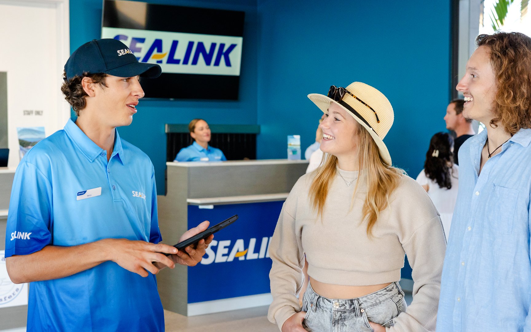 Sealink staff assisting tourists at Airlie Beach terminal for Hill Inlet Lookout and Whitehaven Beach Cruise.