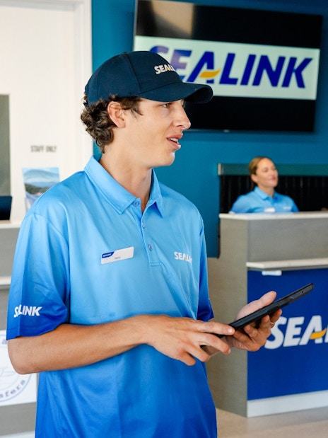 Sealink staff assisting tourists at Airlie Beach terminal for Hill Inlet Lookout and Whitehaven Beach Cruise.