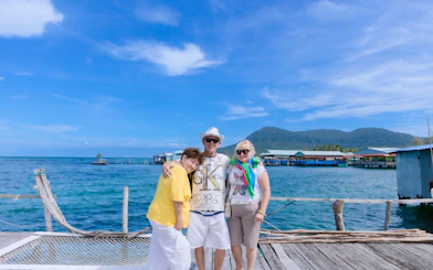 Tourists on a dock with Xuong Island in the background, Vietnam.