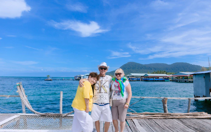 Tourists on a dock with Xuong Island in the background, Vietnam.