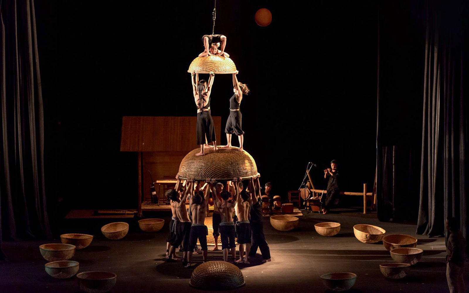 Performers balancing on woven baskets at A O Show circus.