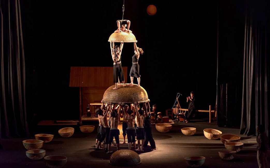 Performers balancing on woven baskets at A O Show circus.
