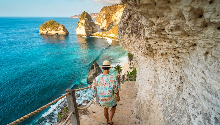 Tourists at Atuh Cliff, Nusa Penida Island, enjoying scenic views during a private tour with hotel transfers.