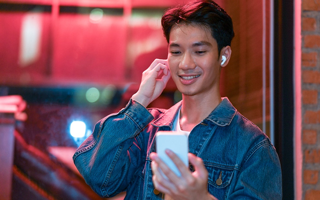 Person using phone for audio tour in Amsterdam's Red Light District.