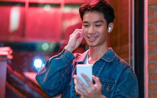 Person using phone for audio tour in Amsterdam's Red Light District.