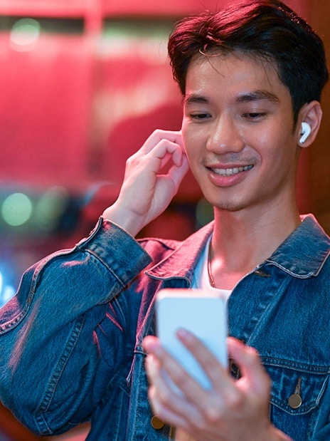 Person using phone for audio tour in Amsterdam's Red Light District.