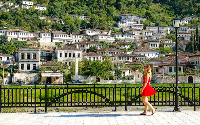 Guest walking in front of traditional Ottoman houses in Berat old town, Albania.