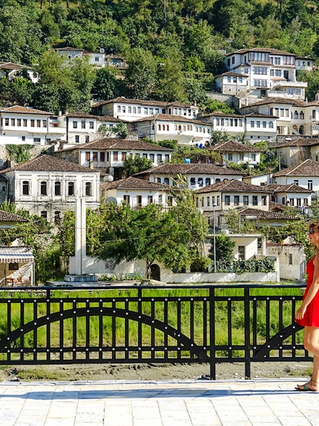 Guest walking in front of traditional Ottoman houses in Berat old town, Albania.