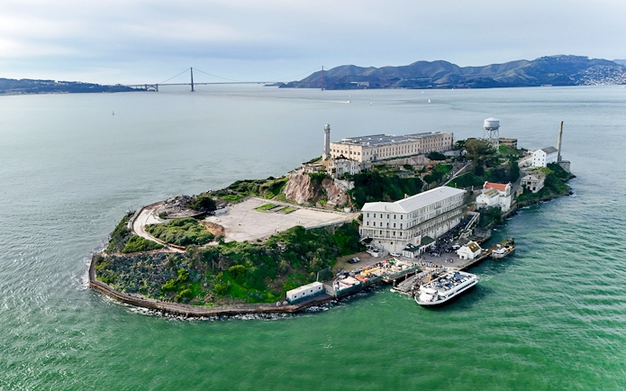 Aerial view of Alcatraz Island with San Francisco skyline in the background.