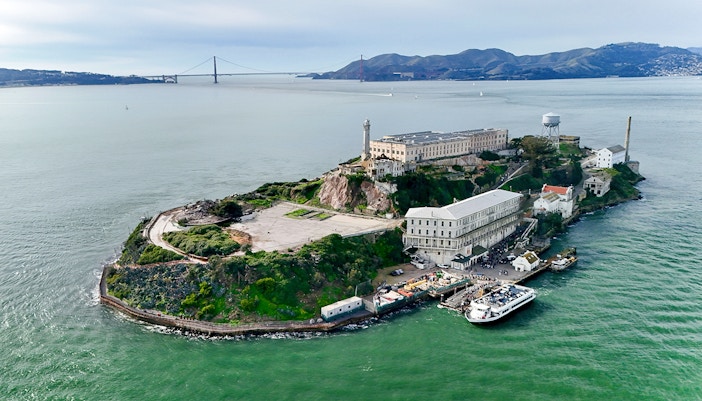 Aerial view of Alcatraz Island with San Francisco skyline in the background.