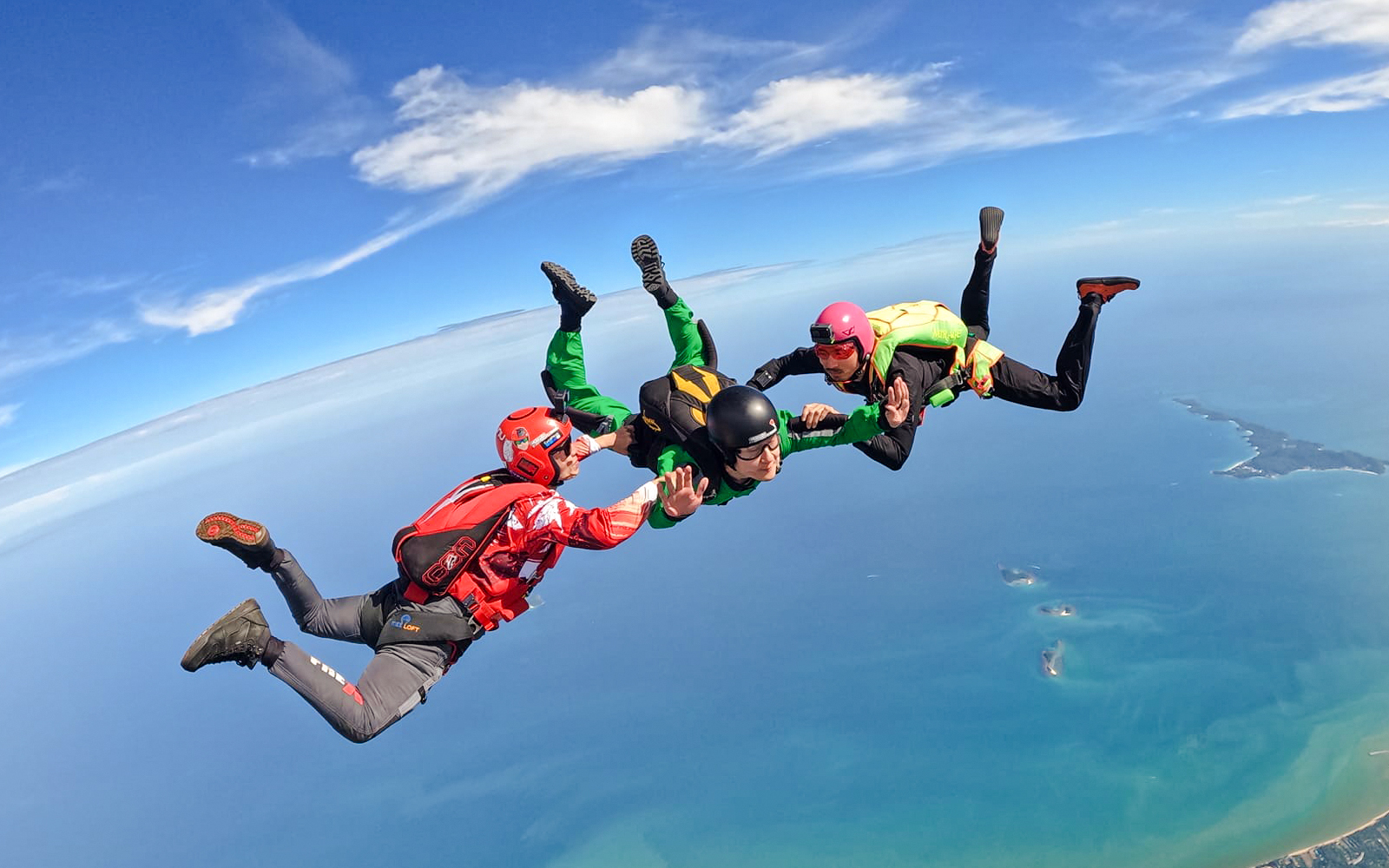 Tandem skydivers freefalling over ocean near Pattaya, Thailand.