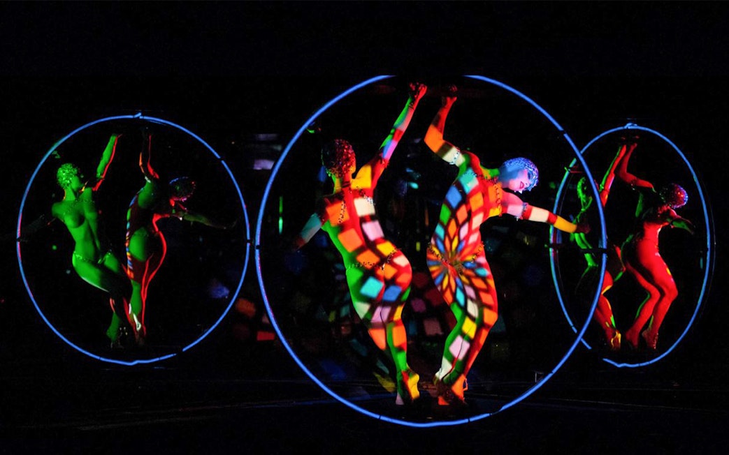 Dancers in colorful lights performing at Crazy Horse Show, Paris.