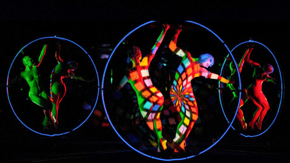 Dancers performing on stage at Crazy Horse Show, Paris, with vibrant lighting.