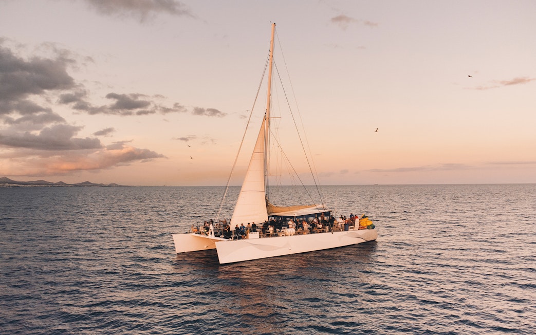 Catamaran with tourists at sunset on a Lanzarote dolphin watching tour.