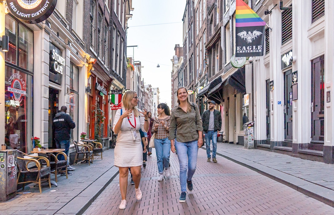Warmoestraat in Amsterdam with vibrant nightlife and historic architecture seen during guided walk tour