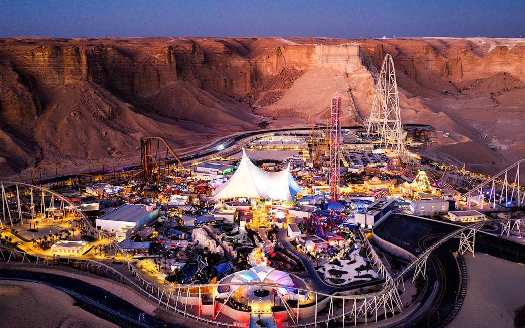 Aerial view of Six Flags Qiddiya City amusement park with roller coasters and attractions.