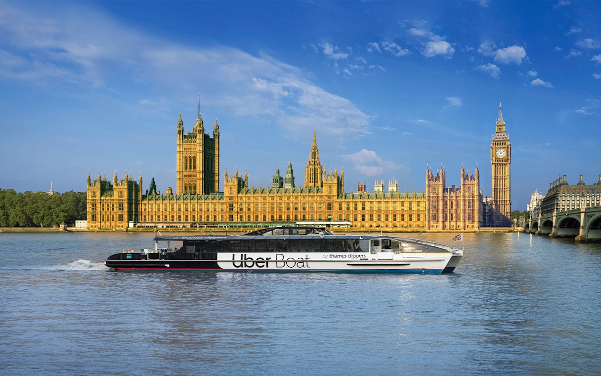 Uber Boat on Thames River passing Westminster Palace, London.